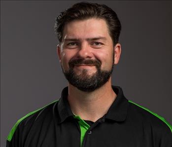 Male Employee smiling in front of a grey back ground 