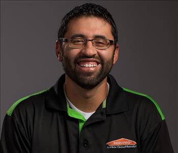 Male Employee smiling in front of a grey back ground 