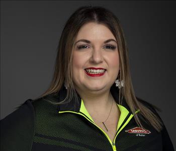 Female Employee smiling in front of a grey back ground