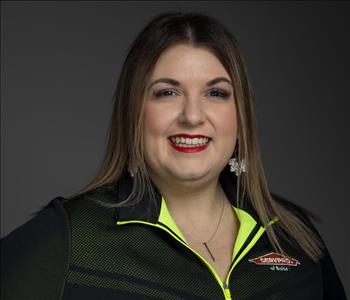 Female Employee smiling in front of a grey back ground 