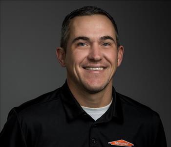Male Employee smiling in front of a grey back ground