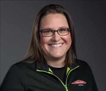 Female Employee smiling in front of a grey back ground